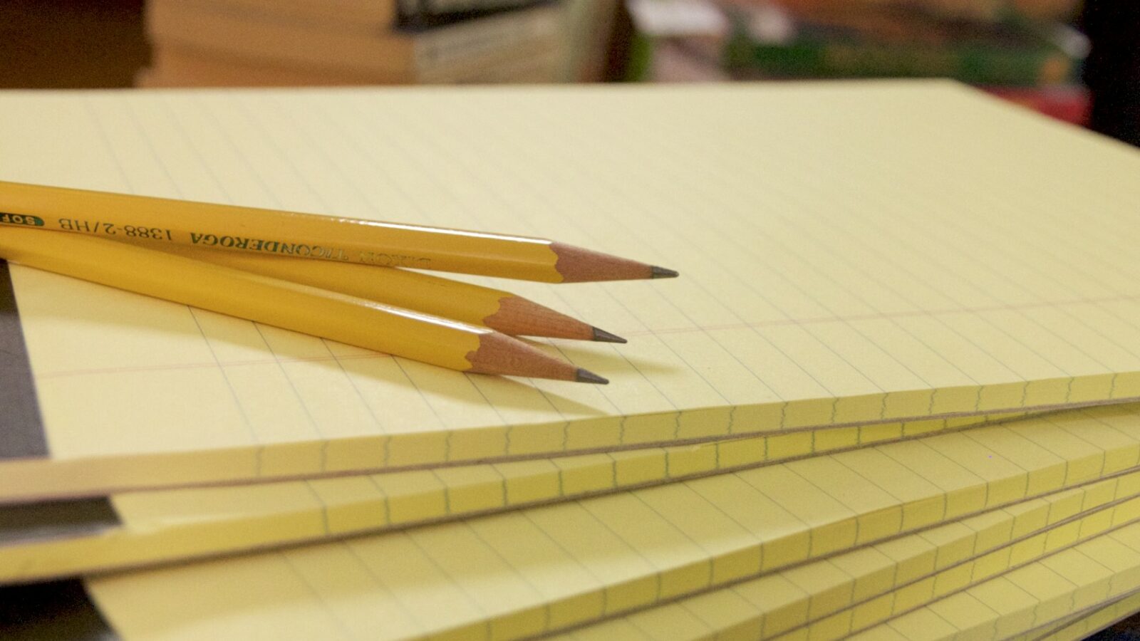 A stack of notepads with pencils