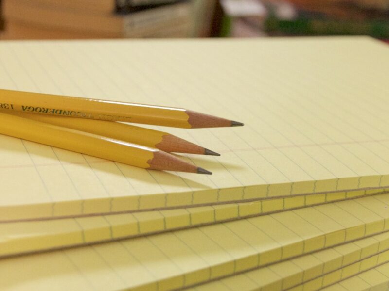 A stack of notepads with pencils